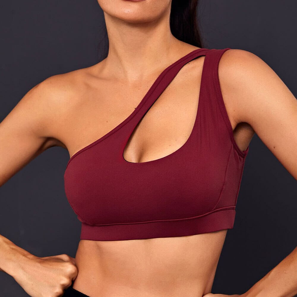 Stylish one-shoulder burgundy sports bra for women, perfect for fitness activities, featuring breathable spandex and nylon for comfort.